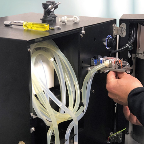 Techniker arbeitet an den internen Komponenten eines trinkForm® Getränkeautomaten – Stellenangebot für technisches Personal