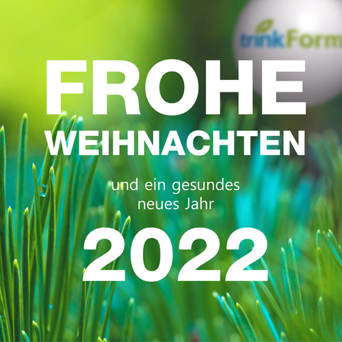 Weihnachtskugel im Gras mit den Wünschen von trinkForm® für Frohe Weihnachten und ein gesundes Jahr 2022